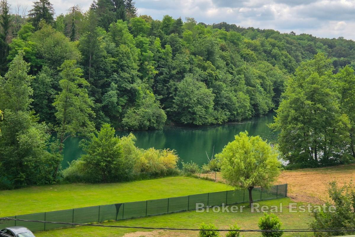 Maison entourée de verdure près de la rivière