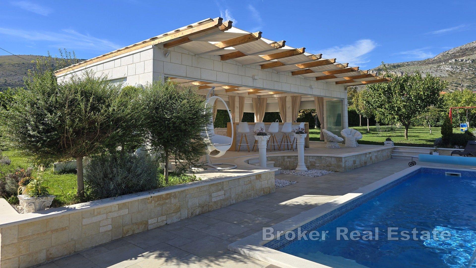 Steinhus med svømmebasseng og stor hage